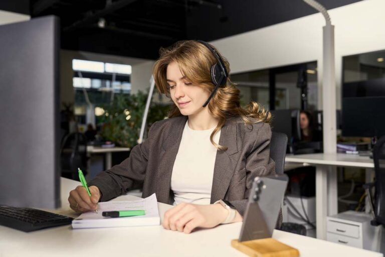 Mulher satisfeita com auscultadores toma notas